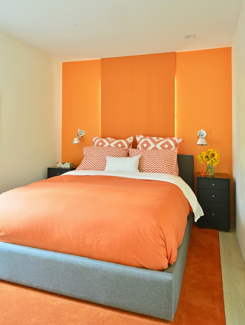 不同於客廳的大地色調，臥房大膽地投入亮麗的橘紅色調。